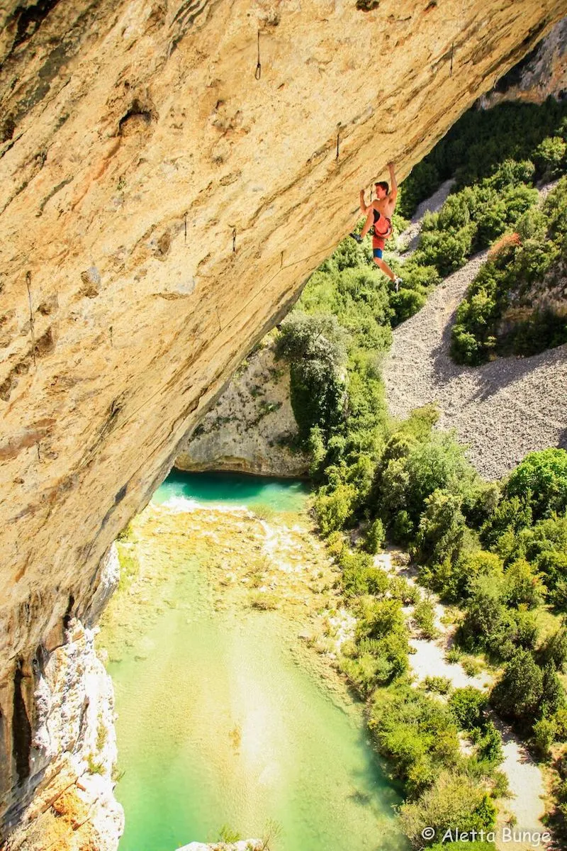 Photography of Sebastien Bouin climbing a mountain with a lake in the background