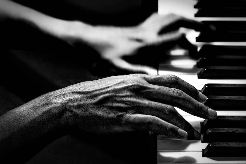 Hands playing piano by Noemia Prada