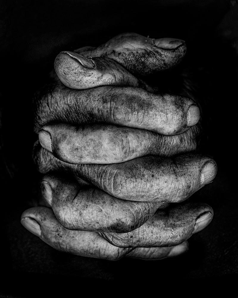 Mains d'ouvrier aux doigts croisés par Noemia Prada, portraitiste de mains en noir et blanc