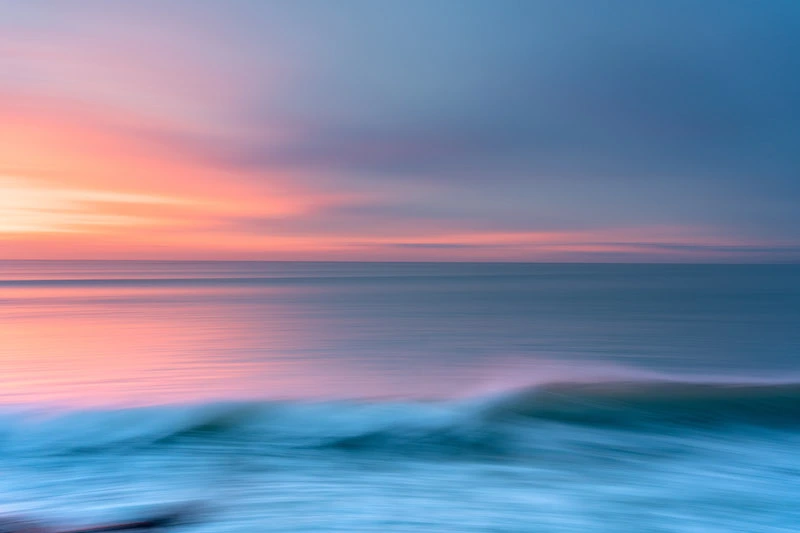 Photographie d'un coucher de soleil se reflétant sur la mer