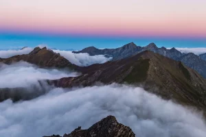 Lanscape with mountains and a violet sky with clouds taken by Damian Markut via Unsplash
