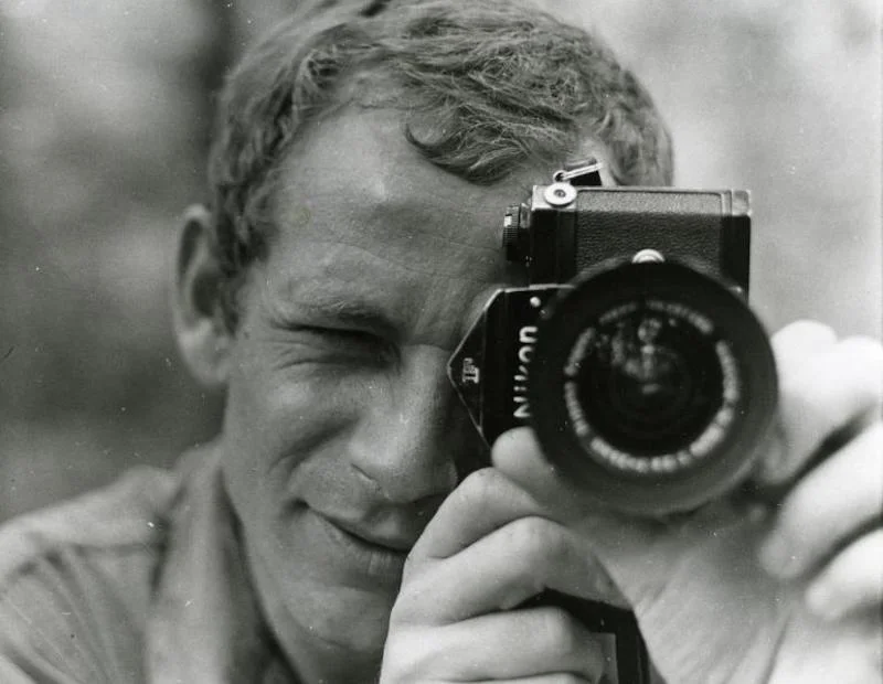 Portrait de Gilles Caron tenant un appareil photo