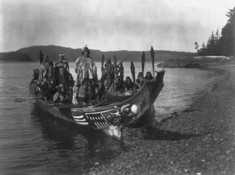 Native American tribe on a boat near the coastline