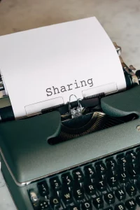 Typewriter with the word "sharing" for emotions and photography