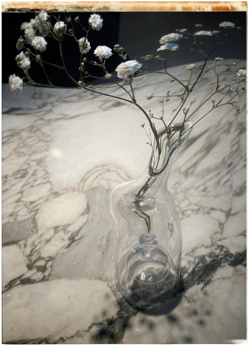 Retouche sur la photo d'un vase en cristal avec des fleurs blanches