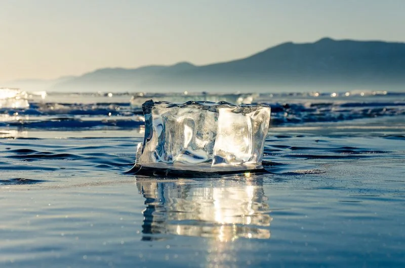 Fonte d'un bloc de glace sur une côte du Baïkal, montrant l'impact sur le climat