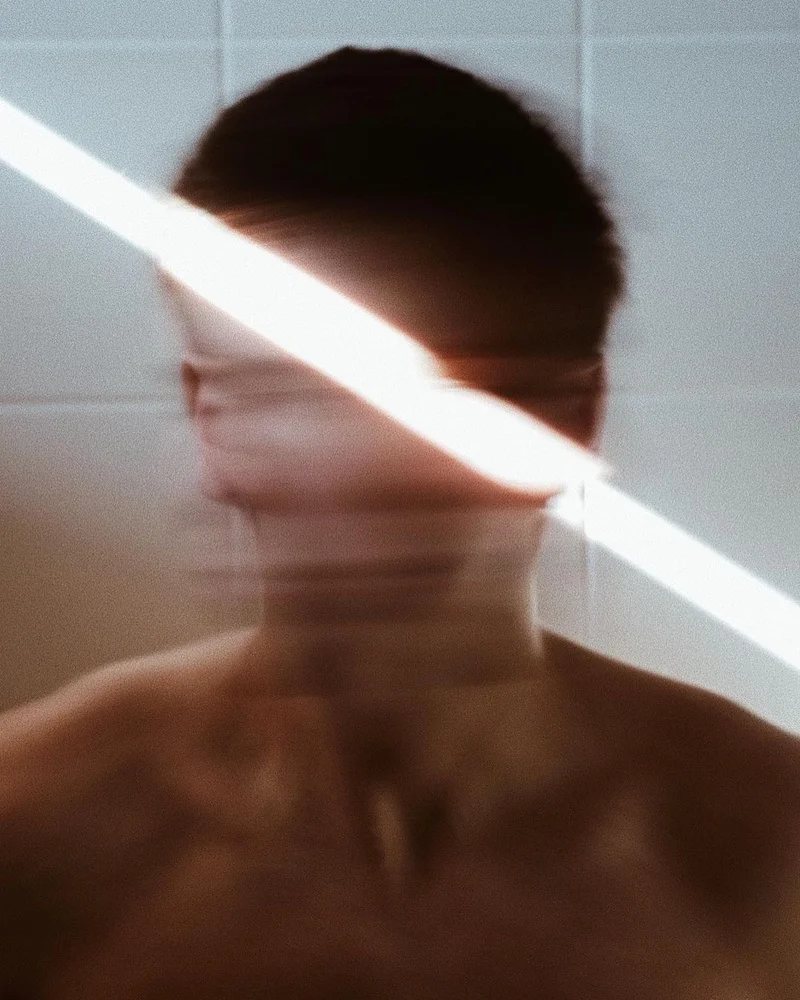 Blurred man's face with a beam of light