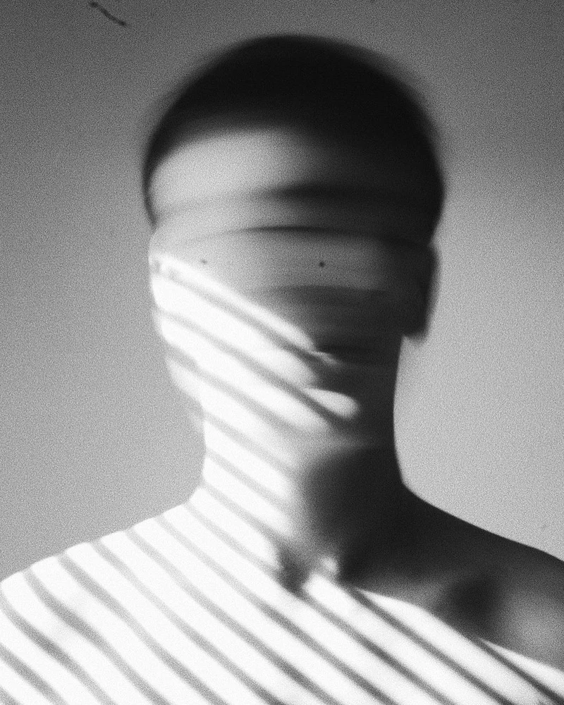 Blurred man's face with beams of light in black and white