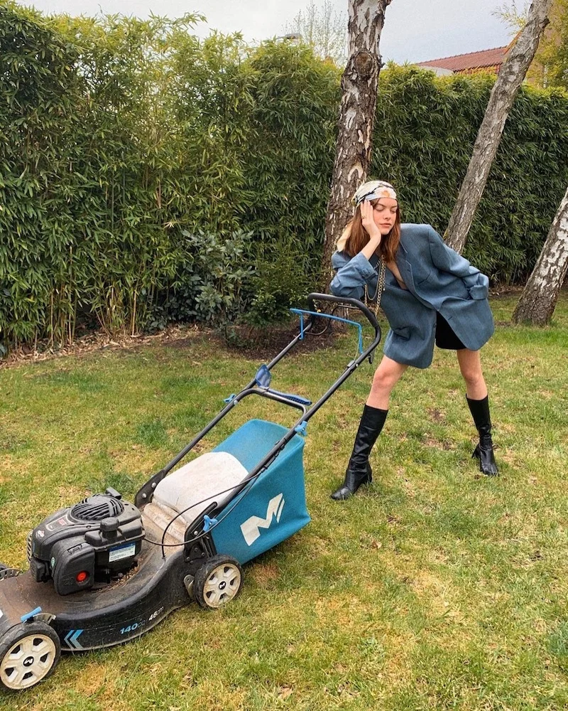 Woman with a mower in a garden, representing the time during quaratine when photographers tried to turn every activity into a fun way during containment.