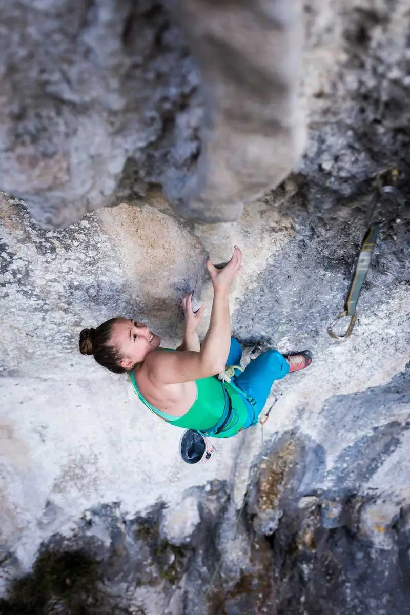 Photographie d'une femme escaladant une montagne