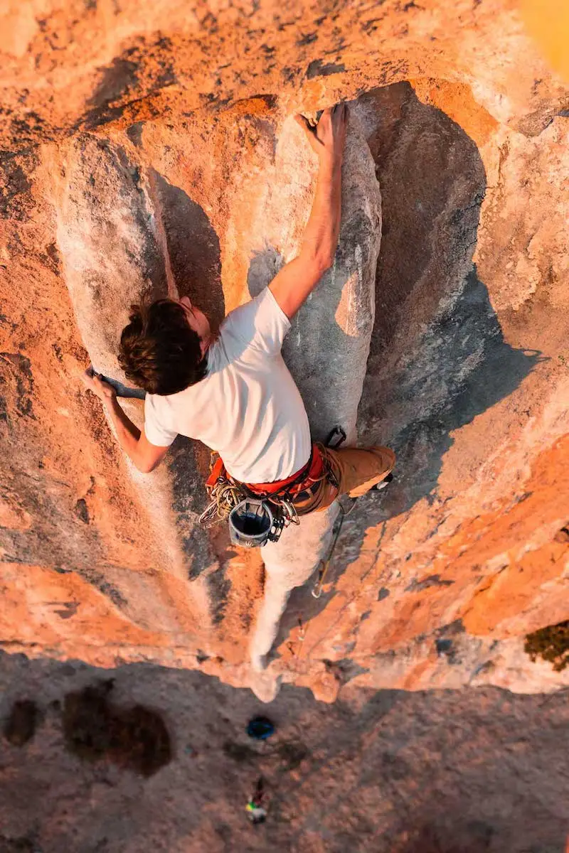 Photographie d'un homme escaladant une montagne en plein soleil