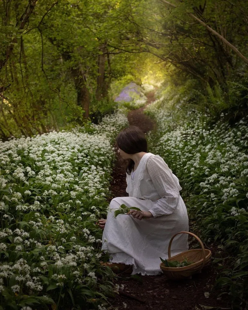 Photographie d'une femme ramassant des fleurs dans un champ, prise par Aimee Twigger, photographe culinaire