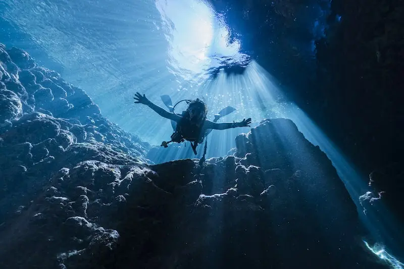 Photographie d'un plongeur en lumière naturelle sous l'eau