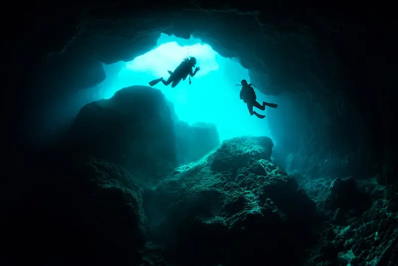 Photographie de plongeurs dans une grotte