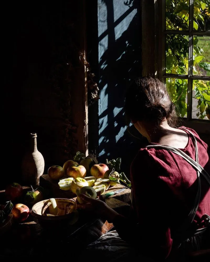Photographie d'une femme devant une table avec des fruits, prise par Aimee Twigger