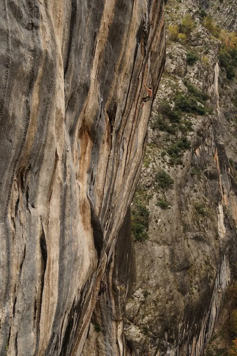 Photography of a man climbing a mountain with his bare hands