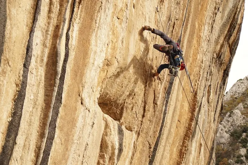 Photographie d'un homme escaladant une montagne