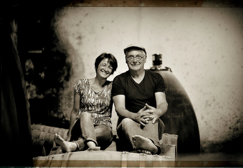 Portrait de Pierre et Estelle sur une barrique de vin du Domaine Clavel