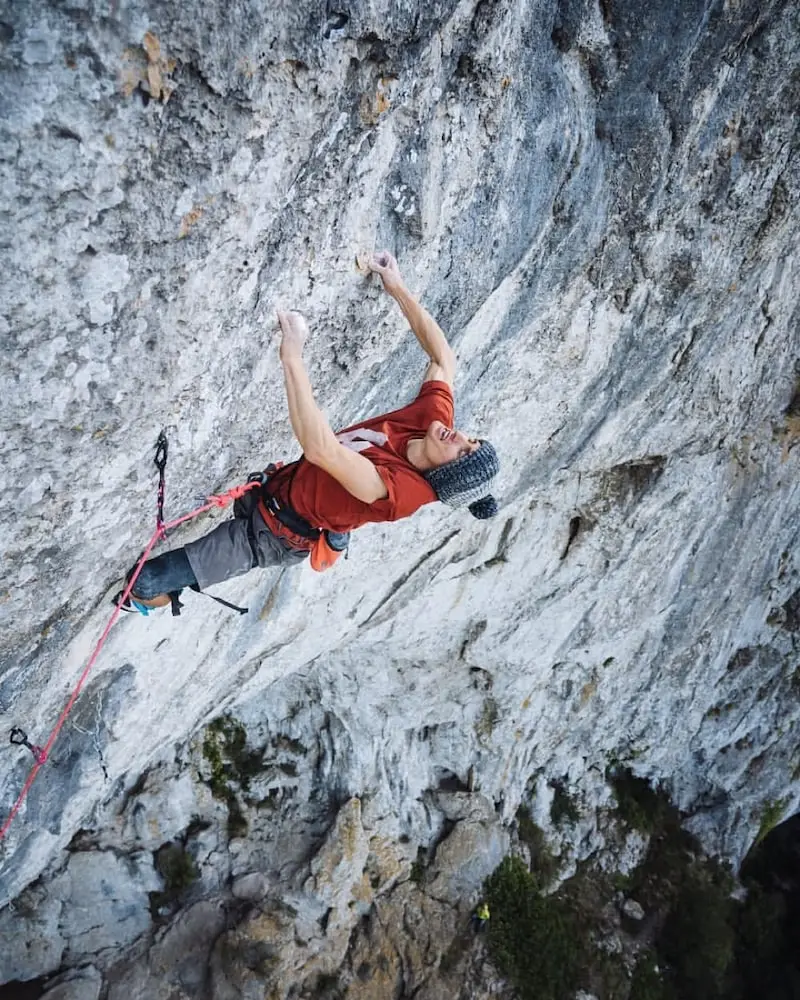 Photographie d'un homme escaladant une montagne