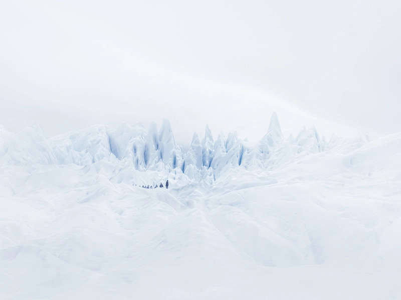 Photographie d'un paysage recouvert de neige avec quelques personnes en arrière-plan