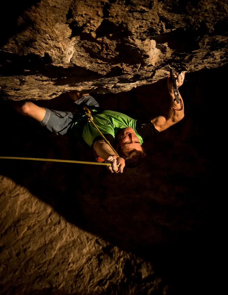 Photography of Seb Bouin climbing in the darkness on a cliff