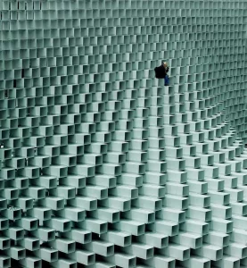 Photography of a builder on a building made out of white rectangular prisms