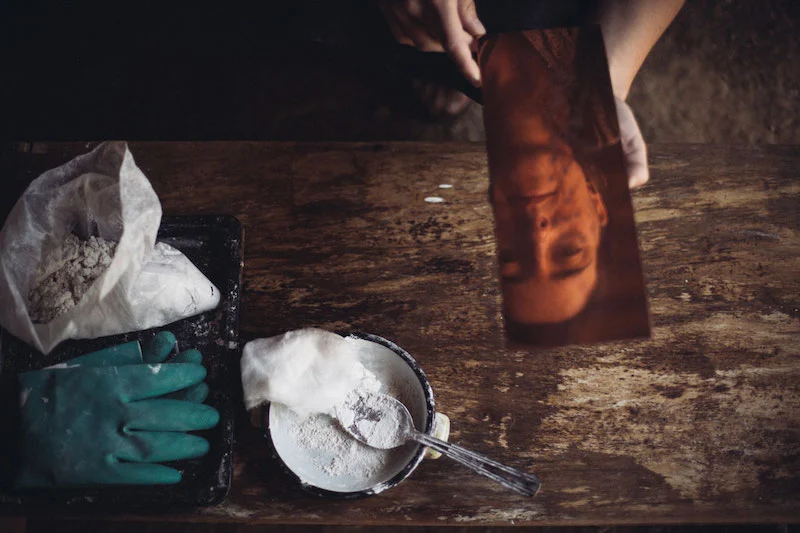 Photography of the reflection of a person on a mirror with utensils in the background