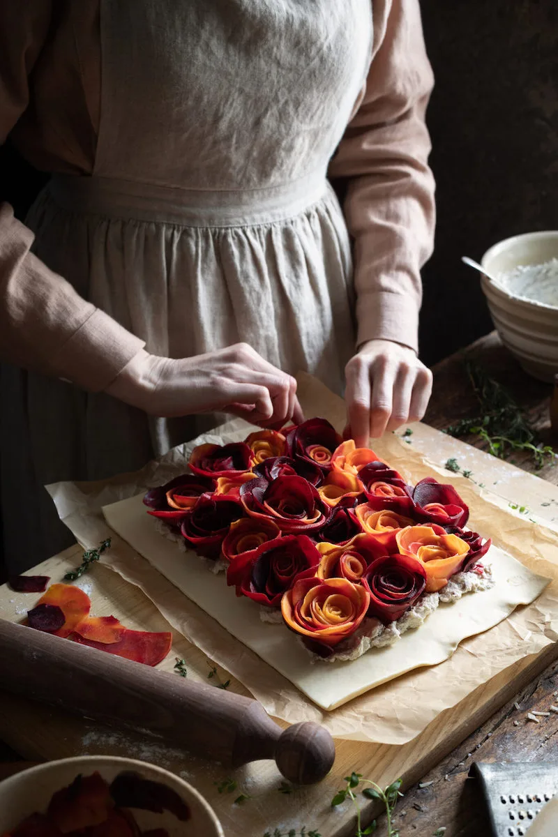 Photographie d'une femme créant des roses avec de la nourriture, prise par Aimee Twigger, photographe culinaire